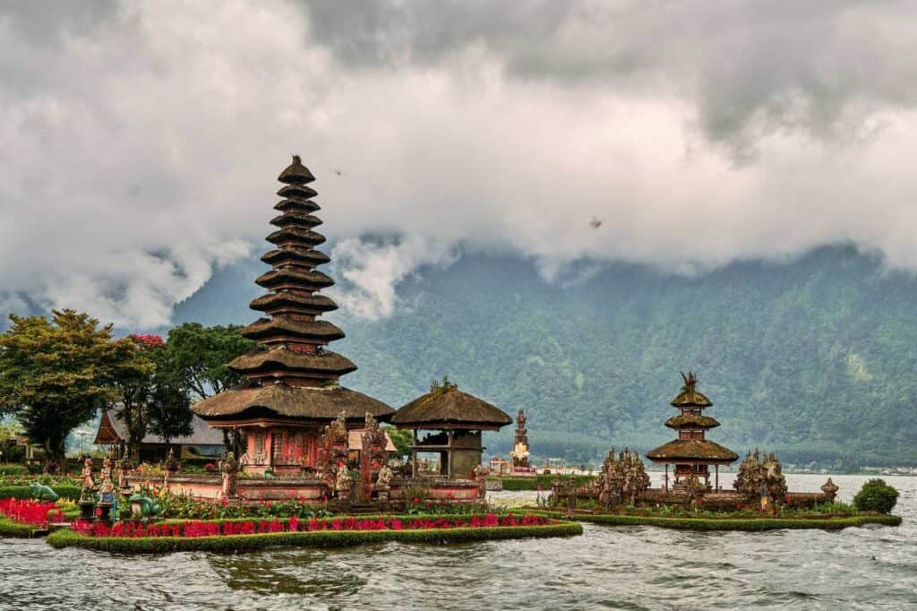 Ulun Danu Beratan Temple in Bali, Indonesia, situated on the shores of Lake Beratan with misty mountains in the background. The temple’s iconic multi-tiered pagodas and surrounding gardens are reflected in the calm waters, creating a serene and spiritual atmosphere.