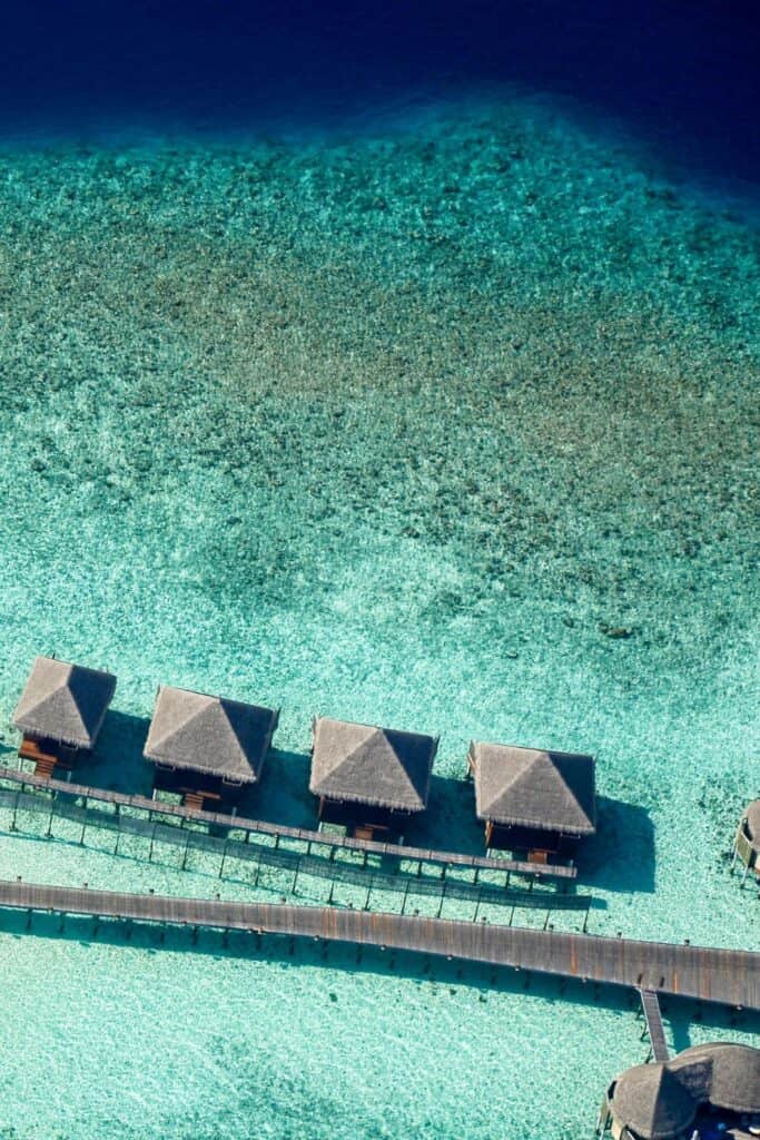 aerial view of overwater villas in the maldives in turquoise waters