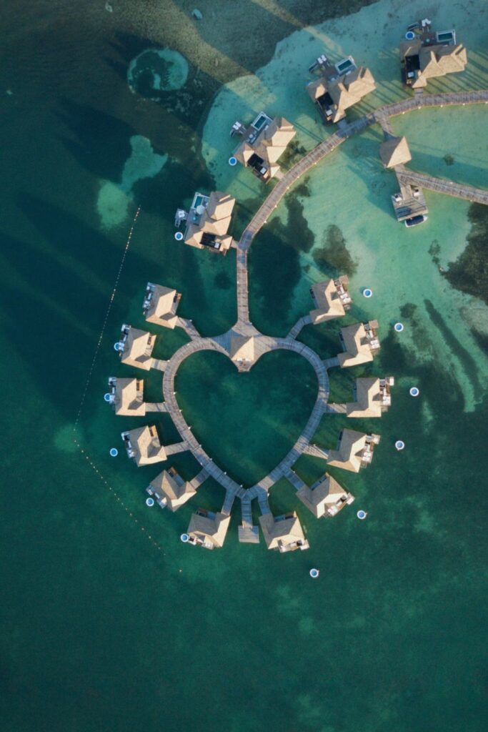 aerial view of overwater villas in a heart shape in a green lagoon in sandals resort jamaica